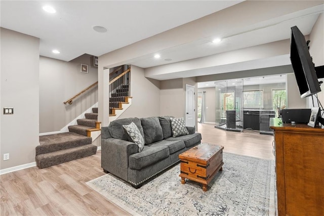 living room with recessed lighting, baseboards, stairs, and wood finished floors