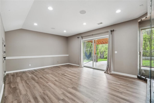 spare room with baseboards, a wealth of natural light, wood finished floors, and visible vents