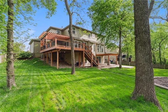 rear view of property featuring fence, a wooden deck, stairway, a patio area, and a yard