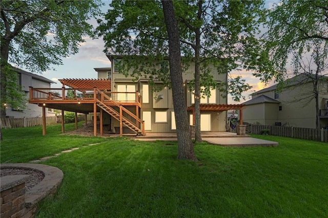 back of property at dusk featuring fence, a wooden deck, stairs, and a patio area