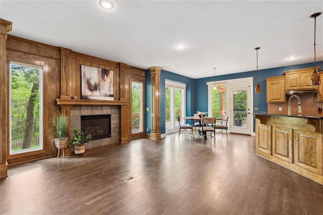 living area with recessed lighting, dark wood-style flooring, and a tile fireplace