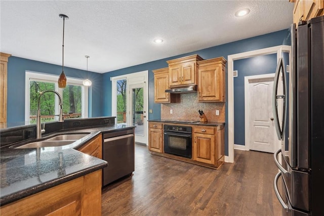 kitchen with dark wood-style flooring, a textured ceiling, under cabinet range hood, a sink, and black appliances