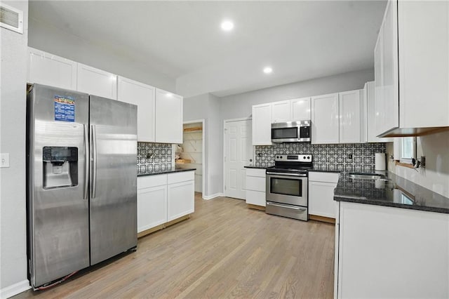 3945 SW Batten Dr, Lees Summit, MO 64082 - kitchen with stainless steel appliances, decorative backsplash, recessed lighting, light wood-type flooring, and white cabinetry