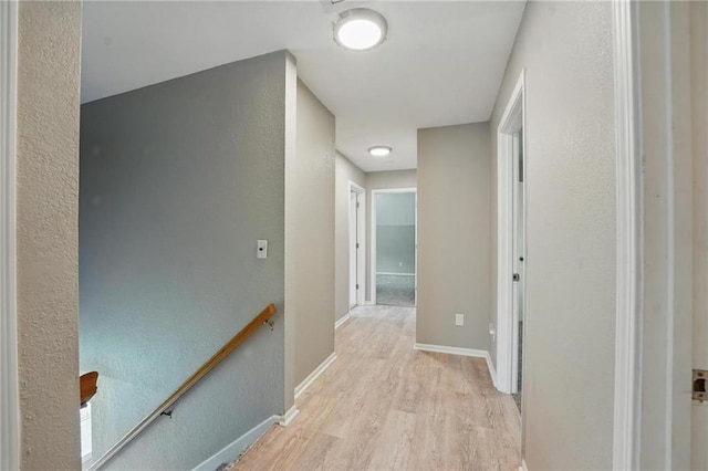 3945 SW Batten Dr, Lees Summit, MO 64082 - hallway featuring an upstairs landing, light wood-style floors, a textured wall, and baseboards