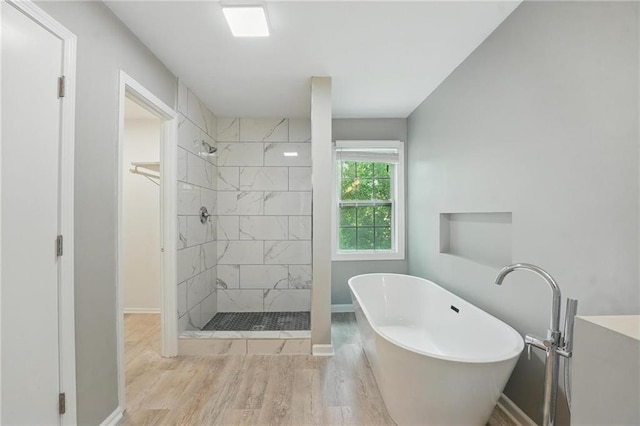 3945 SW Batten Dr, Lees Summit, MO 64082 - bathroom featuring a freestanding tub, baseboards, wood finished floors, and tiled shower
