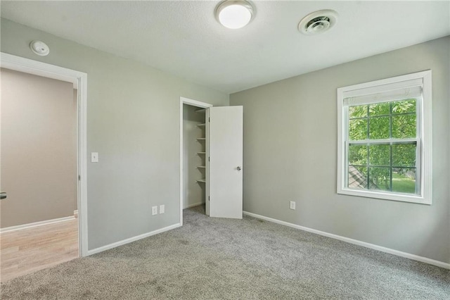 3945 SW Batten Dr, Lees Summit, MO 64082 - unfurnished bedroom featuring carpet floors, baseboards, a spacious closet, and a closet