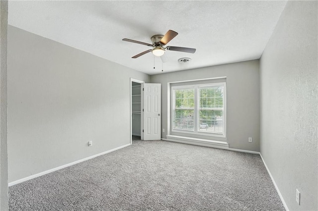 3945 SW Batten Dr, Lees Summit, MO 64082 - unfurnished bedroom with baseboards, carpet, a textured wall, ceiling fan, and a spacious closet