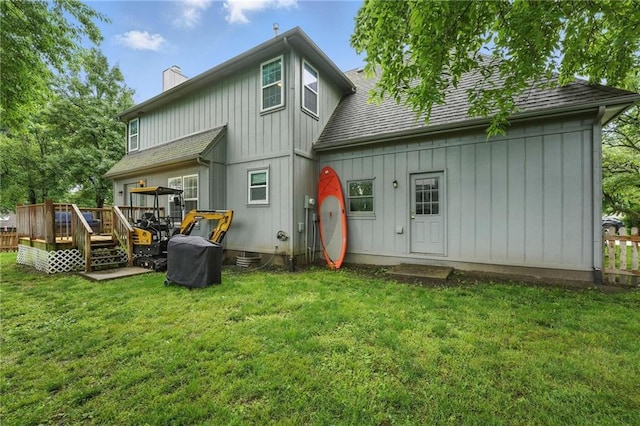 3945 SW Batten Dr, Lees Summit, MO 64082 - back of property with board and batten siding, a chimney, a wooden deck, and a yard