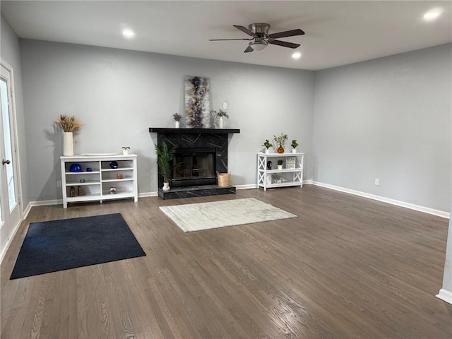 3945 SW Batten Dr, Lees Summit, MO 64082 - living area featuring a ceiling fan, a fireplace with raised hearth, baseboards, recessed lighting, and dark wood-style floors