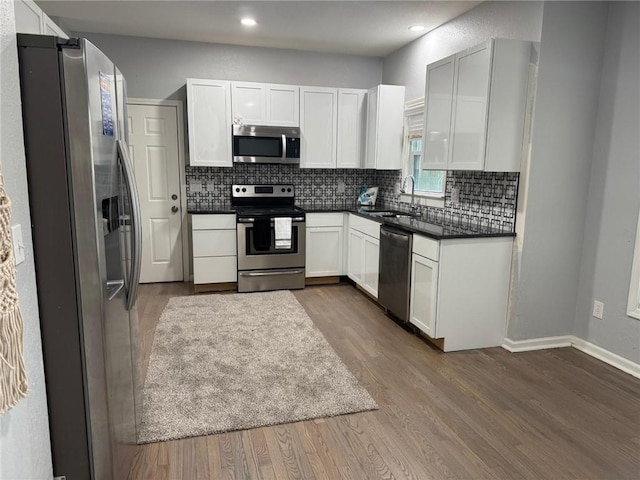 3945 SW Batten Dr, Lees Summit, MO 64082 - kitchen featuring stainless steel appliances, a sink, dark countertops, backsplash, and dark wood-type flooring