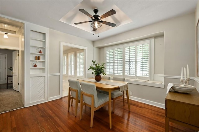 2616 W 47th Ter, Westwood, KS 66205 - dining space featuring a ceiling fan, dark wood-style flooring, built in shelves, and a raised ceiling