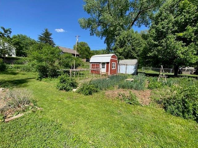 view of yard with an outbuilding, fence, and a storage unit