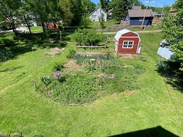 view of yard with an outdoor structure, fence, and a shed