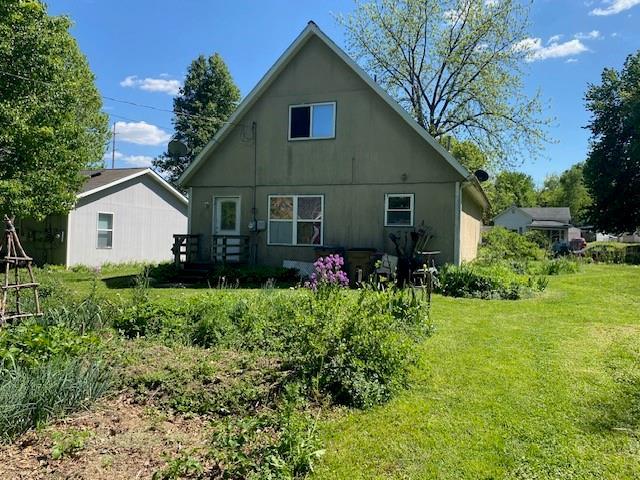 back of property featuring a yard