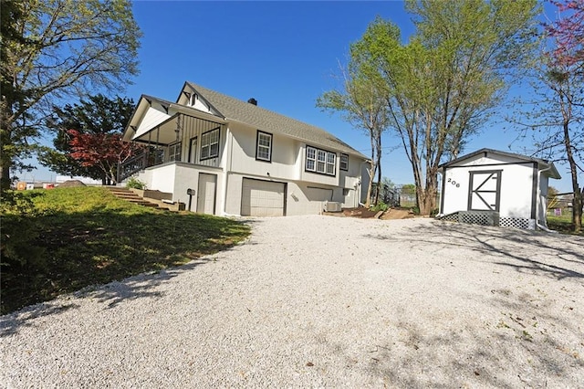 206 SW 22nd St, Blue Springs, MO 64015 - view of side of home featuring an outbuilding, driveway, a garage, stairs, and a shed