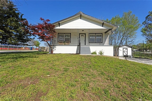 206 SW 22nd St, Blue Springs, MO 64015 - bungalow-style home with a storage shed, a front lawn, an outdoor structure, fence, and a porch
