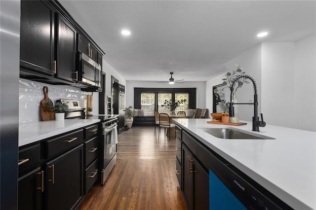 206 SW 22nd St, Blue Springs, MO 64015 - kitchen with dark wood finished floors, stainless steel appliances, dark cabinetry, a sink, and open floor plan