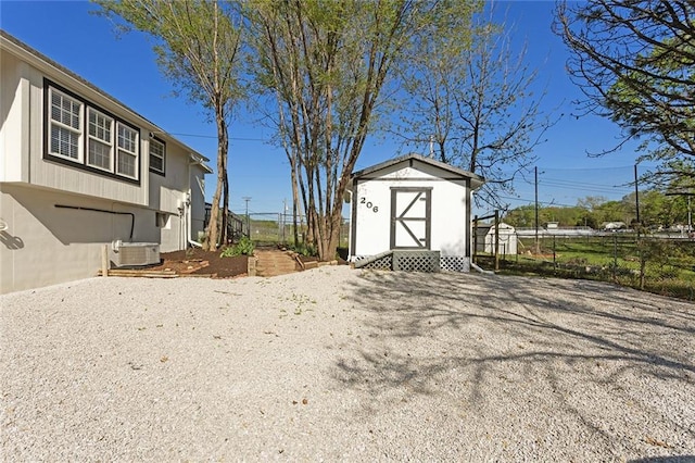 206 SW 22nd St, Blue Springs, MO 64015 - exterior space with a storage shed, central air condition unit, an outbuilding, and fence