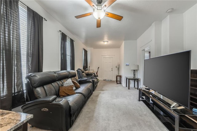 living area featuring plenty of natural light, a ceiling fan, and light colored carpet