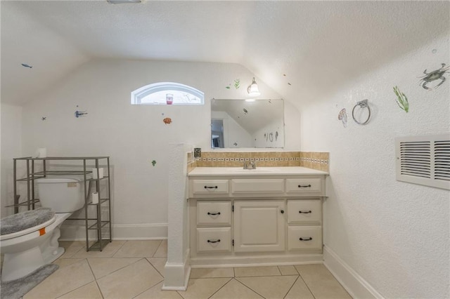 bathroom featuring tile patterned flooring, lofted ceiling, and toilet