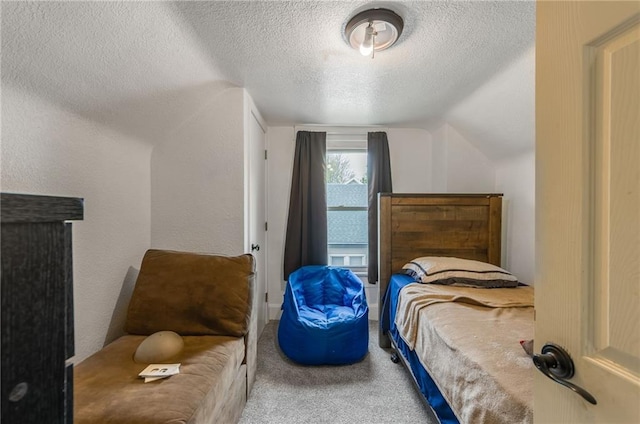 carpeted bedroom featuring a textured ceiling and lofted ceiling