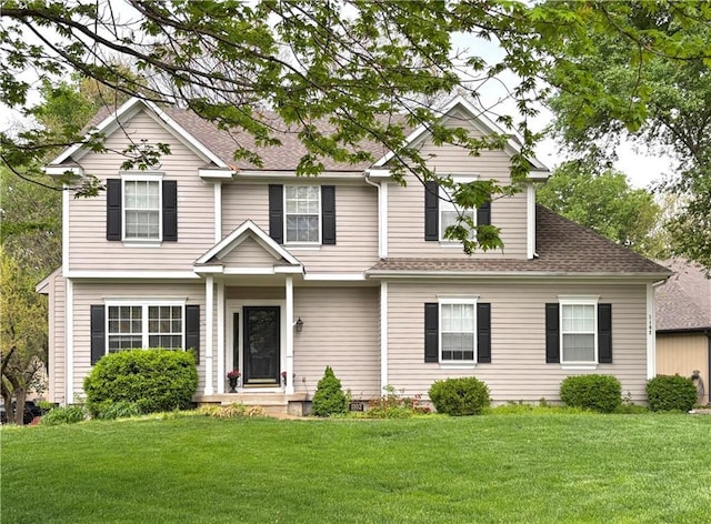 view of front of property featuring roof with shingles and a front yard