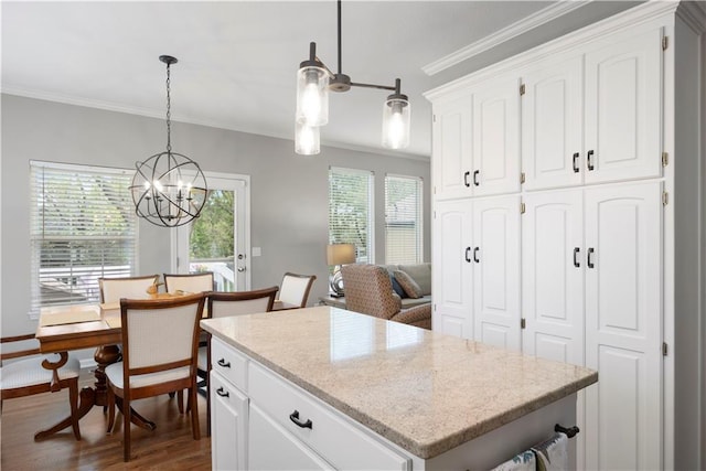 kitchen with a kitchen island, dark wood-style flooring, ornamental molding, and white cabinetry