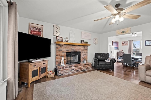 living room featuring a ceiling fan, wood finished floors, and a fireplace