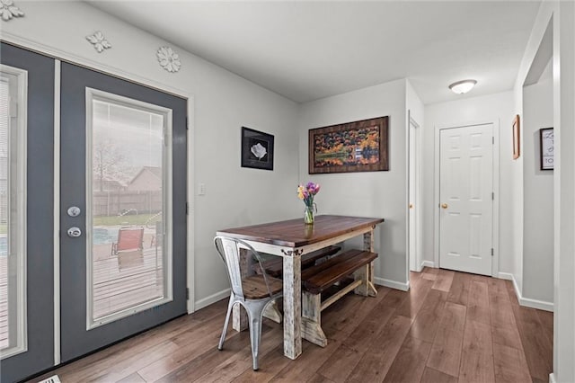 dining space featuring baseboards and wood finished floors
