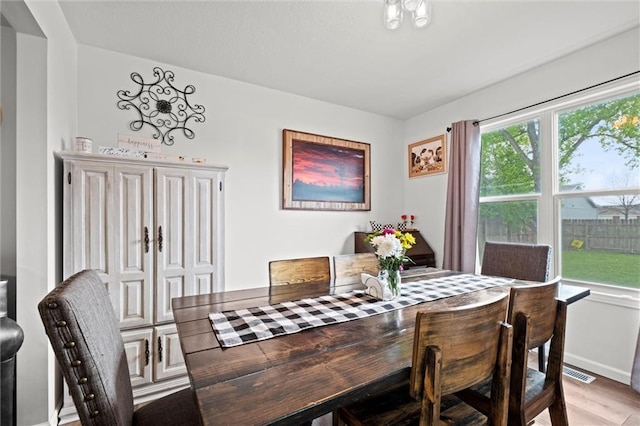 dining area with baseboards and light wood-type flooring