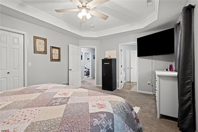bedroom with ceiling fan, light carpet, a raised ceiling, visible vents, and ornamental molding