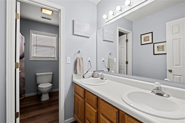 full bathroom featuring visible vents, a sink, wood finished floors, and double vanity