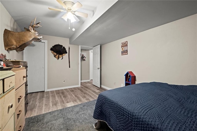 bedroom with baseboards, a ceiling fan, and wood finished floors