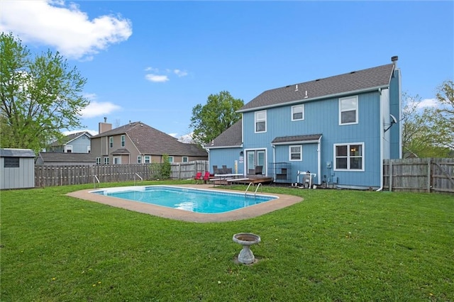 back of house with a fenced backyard, a shed, and a yard