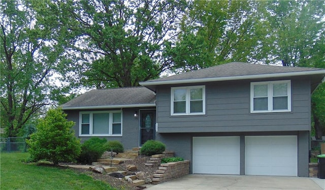 1803 Bird Ter, Harrisonville, MO 64701 - tri-level home with a garage, roof with shingles, fence, and driveway