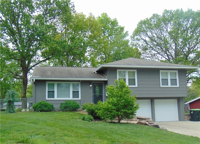 1803 Bird Ter, Harrisonville, MO 64701 - split level home with concrete driveway, an attached garage, fence, and a front yard