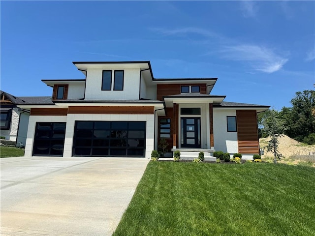 view of front of home featuring a front lawn, concrete driveway, and an attached garage