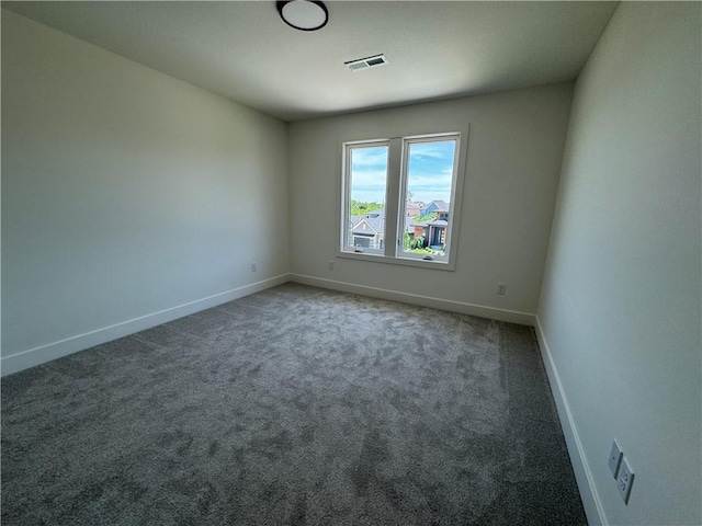 carpeted spare room with visible vents and baseboards