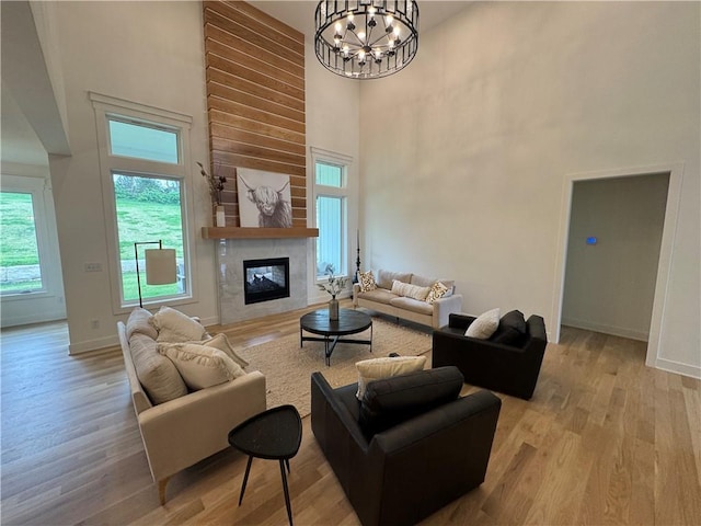 living room featuring a towering ceiling, a chandelier, and wood finished floors