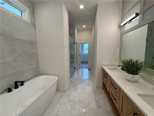 full bathroom featuring a freestanding tub, a stall shower, a healthy amount of sunlight, and marble finish floor