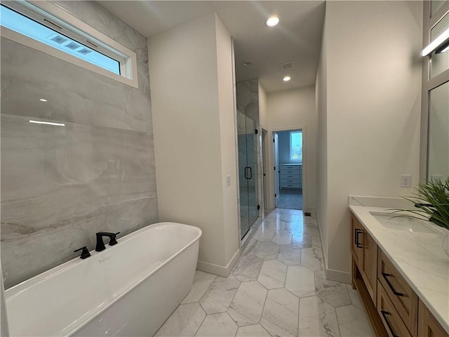 full bath featuring recessed lighting, vanity, a stall shower, baseboards, and a soaking tub