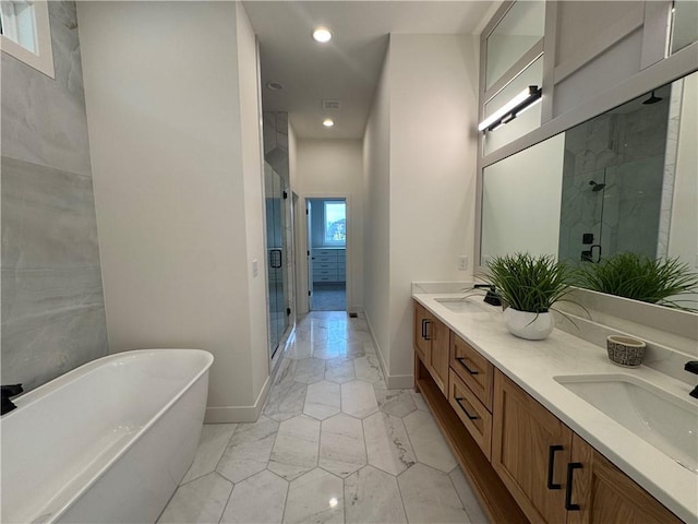 bathroom with a freestanding bath, a shower stall, double vanity, marble finish floor, and baseboards