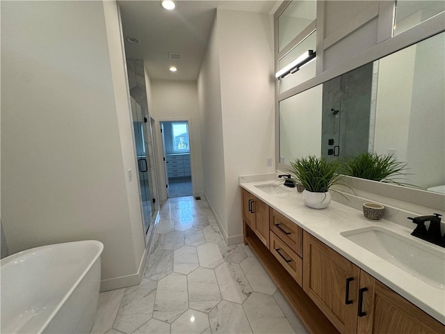 bathroom with marble finish floor, a sink, baseboards, a stall shower, and a soaking tub