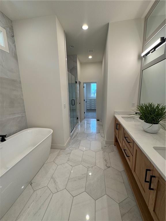 full bath featuring double vanity, a shower stall, a freestanding bath, and marble finish floor