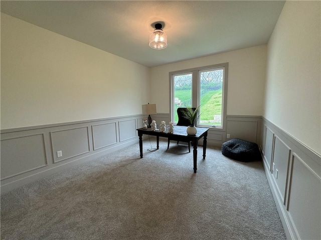 office area featuring a decorative wall, wainscoting, and carpet floors