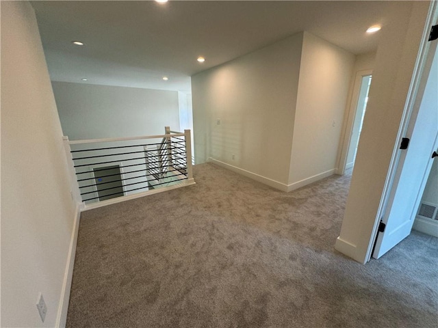 carpeted empty room featuring baseboards, recessed lighting, and visible vents