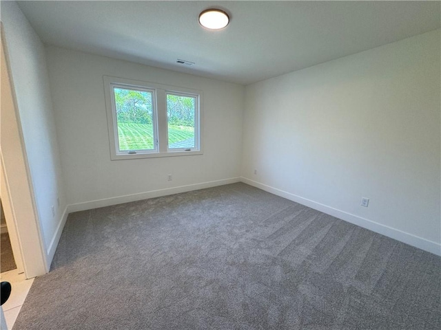 spare room featuring visible vents, carpet flooring, and baseboards