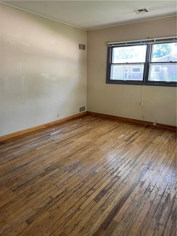915 W 4th St, Chanute, KS 66720 - spare room with wood-type flooring and baseboards
