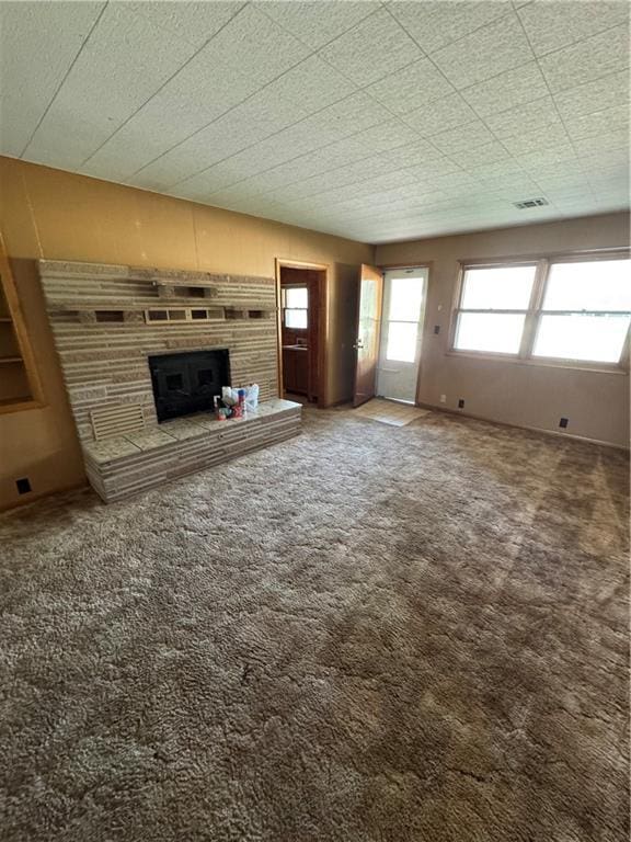 915 W 4th St, Chanute, KS 66720 - unfurnished living room featuring a fireplace and carpet floors