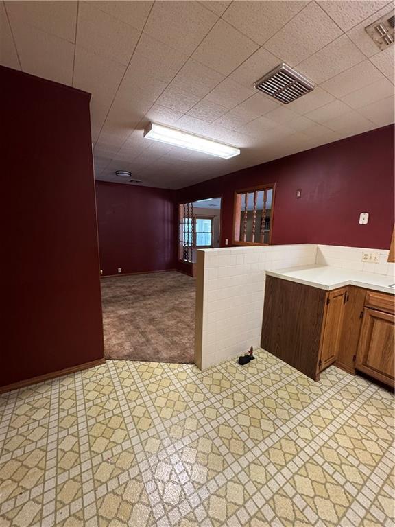 915 W 4th St, Chanute, KS 66720 - kitchen with light countertops, a peninsula, and light carpet